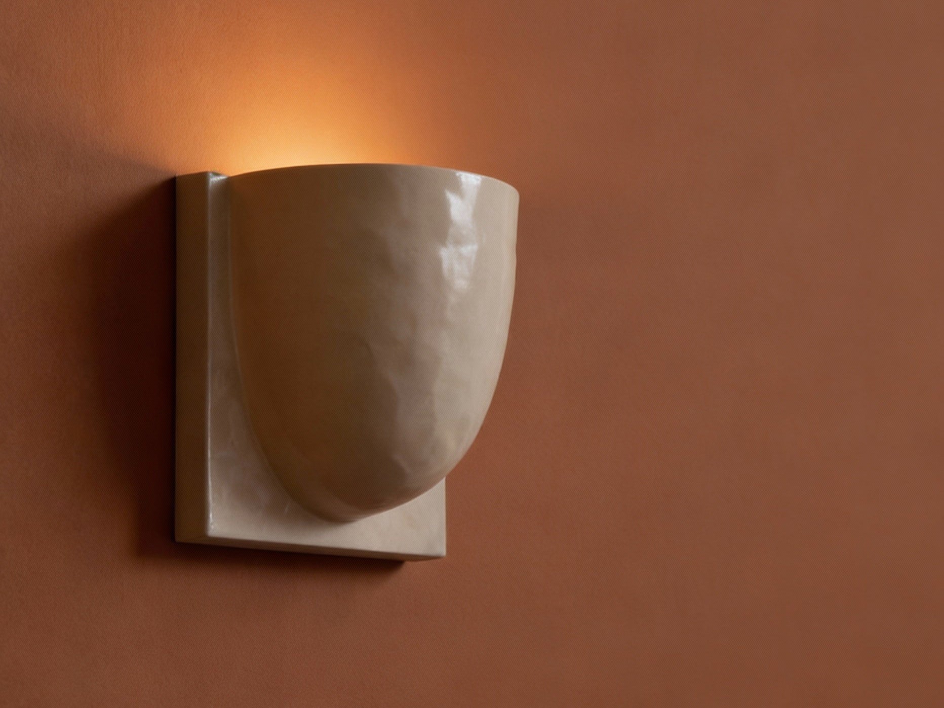 Ceramic wall sconce on a brown wall